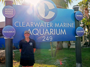 Photo of happy student scholarship recipient in front of the Clearwater Marine Aquarium sign