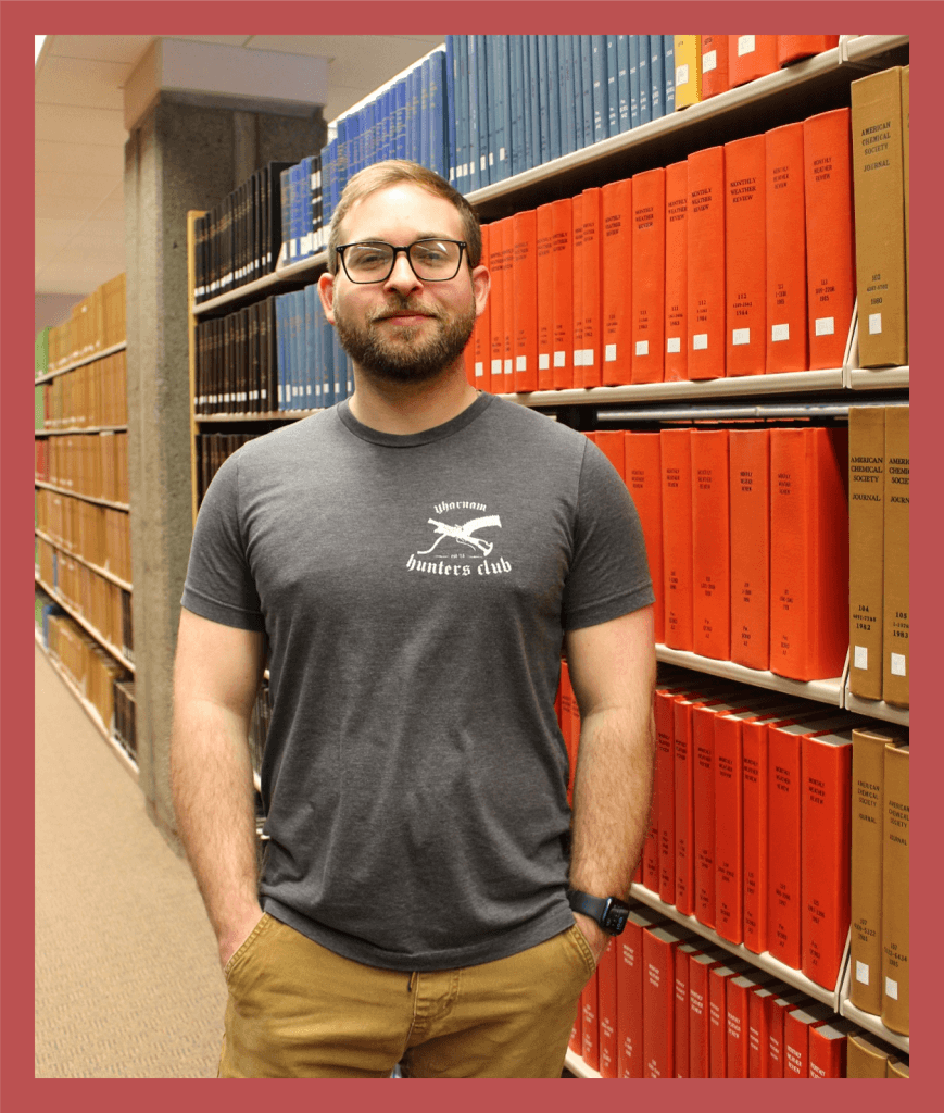 Dylan, Responder, standing in front of a bookshelf