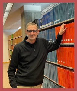 Image of Dr. John, a responder, leaning against a bookshelf.